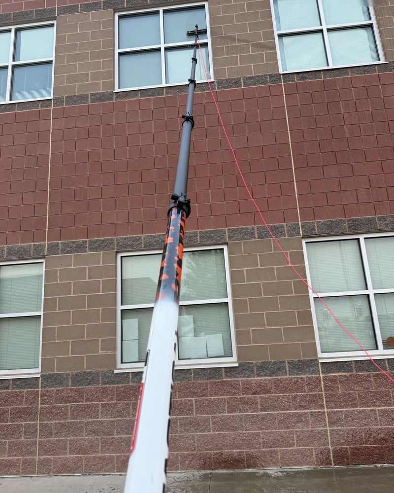 Water-fed pole reaching the high windows of a brick building from the ground